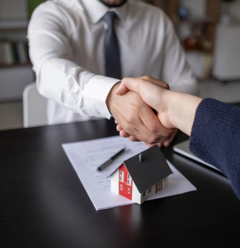 Business handshake and model house