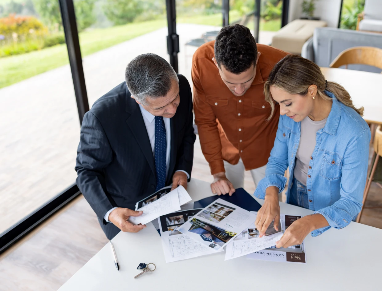 Group analyzing paper documents at desk